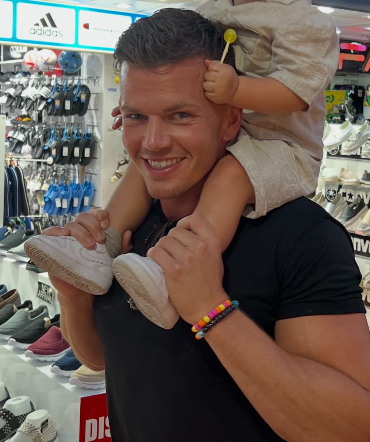 Søren Bælum med sit barn på skuldrene i en skobutik